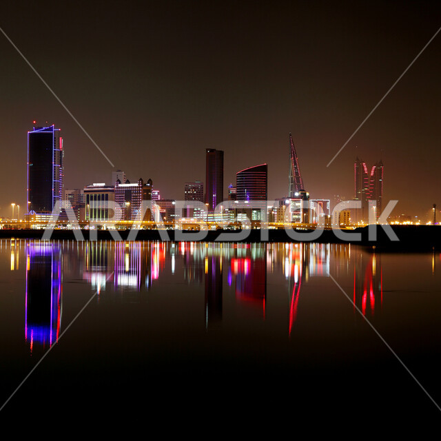Illuminated towers, buildings and skyscrapers overlooking the coast of the Arabian Gulf, famous recreational tourist places in the State of Bahrain, the waterfront of the city of Manama in Bahrain at night, tranquil seascapes