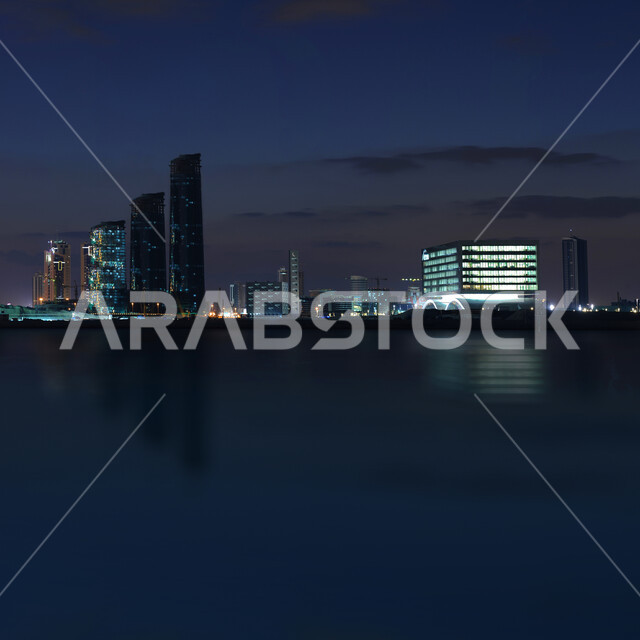 الأبراج والمباني وناطحات السحاب المضيئة المطلة على ساحل الخليج العربي ، أماكن سياحية ترفيهية مشهورة في دولة البحرين، الواجهة البحرية لمدينة المنامة في البحرين في الليل، المناظر البحرية الهادئة