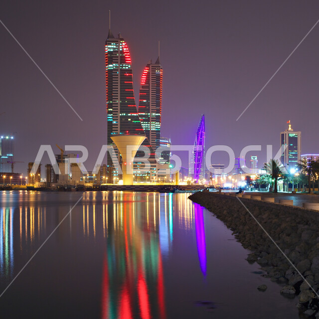 المرفأ المالي المضيء المطل على ساحل الخليج العربي، أماكن سياحية مشهورة في مملكة البحرين، الواجهة البحرية لمدينة المنامة في الليل، المناظر البحرية الهادئة، الفن الهندسي المعماري للأبراج والمباني وناطحات السحاب