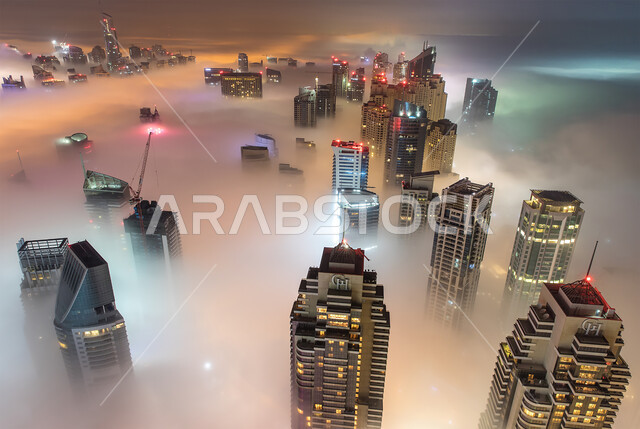 Advanced architectural engineering art of towers and skyscrapers, the road and transportation network in the United Arab Emirates, the view of the foggy atmosphere in the sky, an overhead aerial photo of the Emirate of Dubai in the winter, tourist places and attractions.