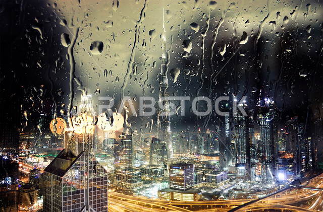 الفن الهندسي المعماري على الطراز الحديث والمتطور للمباني السكنية، أجواء شتوية ماطرة، صورة لقطرات الماء على نافذة زجاجية، التطور العمراني لأبراج وناطحات السحاب في الامارات العربية المتحدة