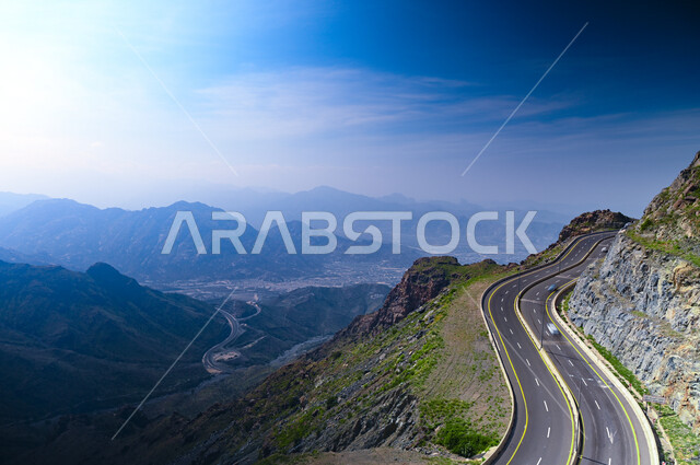 طريق جبلي ملتوي، التكوينات والتشكيلات الصخرية، جبال الهدا في مدينة الطائف غرب المملكة العربية السعودية، الهضاب والمرتفعات الجبلية، النباتات الخضراء والمروج الخصبة، الأجواء الضبابية والمناظر الطبيعية المتميزة