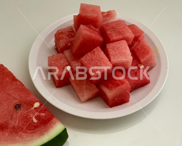 سناكات صحية لذيذة، طبق من البطيخ الأحمر الشهي، المحاصيل الزراعية والمنتجات المحلية في المملكة، الفاكهة الموسمية الصيفية الطازجة في السعودية، خلفية بيضاء