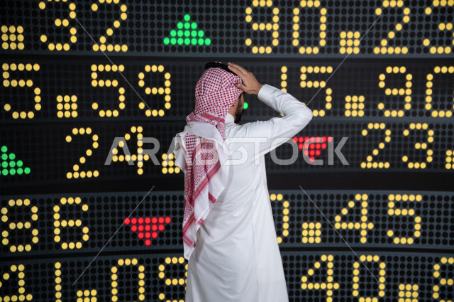 رجل اعمال سعودي خليجي يستخدم البورصة و الاسهم لتطوير اعماله ، ايماءات وجه و يدين تدل على الخسارة و نزول اسهم البورصة ، استخدام تقنية الجرافيكس في عرض نزول و صعود الاسهم  ، أخبار عالمية اقتصادية ،نشرة الإحصاءات الاقتصادية للدول العربية