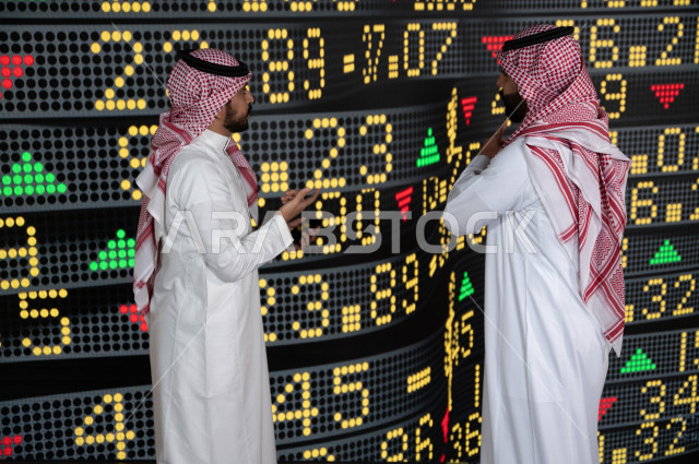 رجال اعمال سعوديان خليجيان  يستخدمان البورصة و الاسهم لتطوير الأعمال و المشاريع ، ايماءات وجه و يدين تدل على الربح و صعود اسهم البورصة ، استخدام تقنية الجرافيكس في عرض نزول و صعود الاسهم  ، أخبار عالمية اقتصادية ،نشرة الإحصاءات الاقتصادية للدول العربية