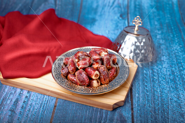 وجبة ذات قيمة غذائية عالية، ضيافة رمضانية لذيذة، رطب من نخيل المملكة العربية السعودية، محاصيل ومنتجات زراعية محلية وطنية سعودية، طبق نحاسي مزخرف مليء بالتمر السكري الصحي الطازج