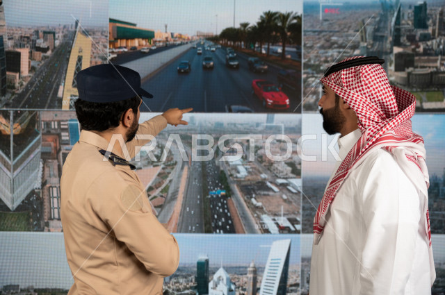 رجل سعودي خليجي يدير القسم الامني  ، يقوم بتتبع كاميرات المراقبة مع رجل الامن الذي يعمل بالمكان ،  ، يرتدي الزي السعودي التقليدي ، الحفاظ على الامن و الطمأنينة ، حراسة و امان 