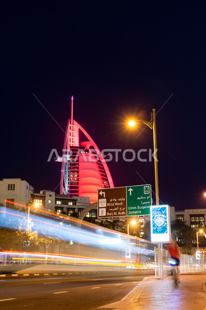Architectural engineering art for residential and commercial buildings and facilities, the Burj Al Arab Hotel in the Emirate of Dubai at night, improving infrastructure and paying attention to paved asphalt roads and streets, urban expansion and progress in the United Arab Emirates