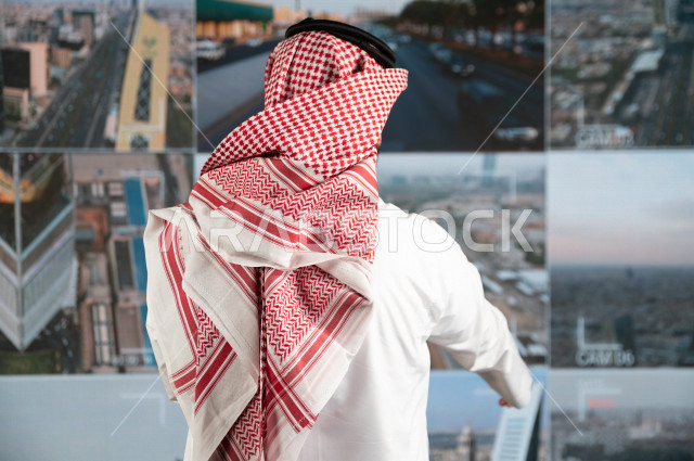 رجل سعودي خليجي يدير القسم الامني  ، يقوم بتتبع كاميرات المراقبة  ، يرتدي الزي السعودي التقليدي ، الحفاظ على الامن و الطمأنينة ، حراسة و امان 