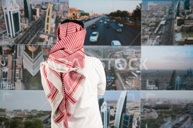 رجل سعودي خليجي يدير القسم الامني  ، يقوم بتتبع كاميرات المراقبة  ، يرتدي الزي السعودي التقليدي ، الحفاظ على الامن و الطمأنينة ، حراسة و امان 