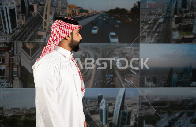 رجل سعودي خليجي يدير القسم الامني  ، يقوم بتتبع كاميرات المراقبة  ، يرتدي الزي السعودي التقليدي ، الحفاظ على الامن و الطمأنينة ، حراسة و امان 