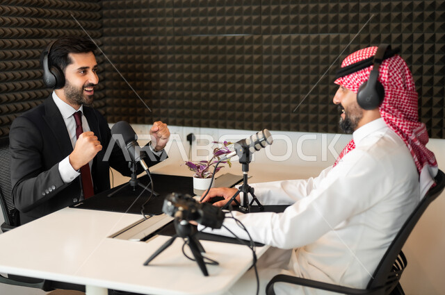 استخدام التقنيات الحديثة، رجل عربي خليجي سعودي يرتدي الثوب والشماغ التقليدي مع رجل بالبدلة الرسمية في مقابلة عمل، تعابير السعادة والسرور، معدات وأجهزة تسجيلات الصوت،  اجراء بث صوتي مباشر ( بودكاست ) عبر برامج التواصل الاجتماعي، ايماءات تدل على الحماس