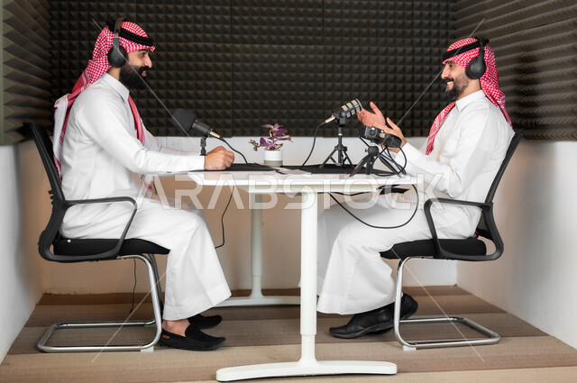 الحوارات بين الزملاء، رجلان عربيان خليجيان سعوديان يرتديان الثوب والشماغ التقليدي في مقابلة عمل داخل مقر الشركة، تعابير الفرح والسرور، معدات وأجهزة تسجيلات الصوت، اجراء بث صوتي مباشر ( بودكاست ) عبر برامج التواصل الاجتماعي، ايماءات الحماس والتفاعل