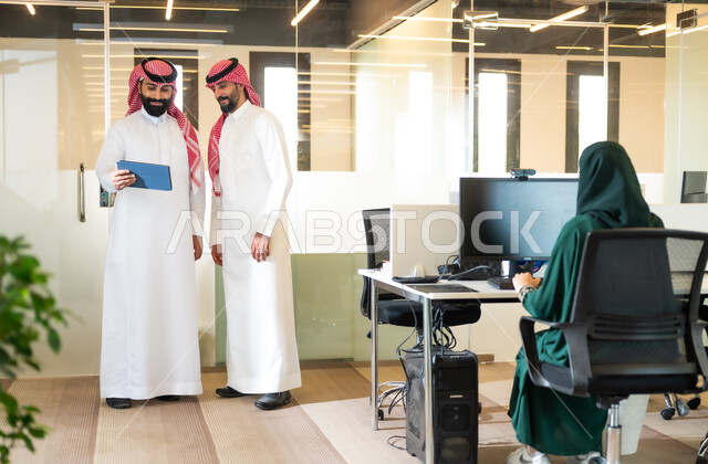 نقاشات ومحادثات عمل، الوحدة والتفاعل الجماعي لتحقيق أهداف الشركة وحل المشكلات،  استخدام الأجهزة والتقنيات الحديثة لتسهيل الأعمال، رجلان عربيان سعوديان خليجيان يرتديان الثوب التقليدي والشماغ داخل مقر الشركة، إنجاز المهام العملية عبر جهاز التابليت