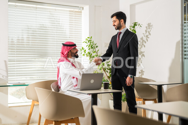 التعاون و المشاركة في إنجاز الأعمال، المصافحة وعقد إتفاقات وصفقات عمل جديدة، تطوير الخطط  وتحقيق أهداف الشركة، رجالا أعمال عربيان خليجيان سعوديان يقومان بإدارة شؤون العمل وتنظيمها عبر الحاسوب، مهن ووظائف إدارية مكتبية