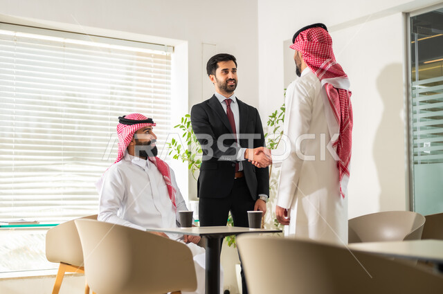 المشاركة والتعاون في إنجاز الأعمال، المصافحة وعقد إتفاقات وصفقات عمل جديدة، تطوير الخطط  وتحقيق أهداف الشركة، رجال أعمال عرب خليجيون سعوديون يقومون بإدارة شؤون العمل وتنظيمها عبر الحاسوب، مهن ووظائف إدارية مكتبية