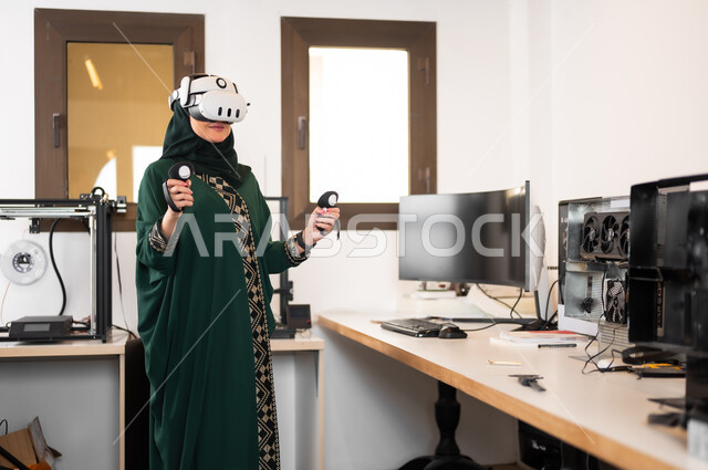 Using advanced modern devices and techniques, simulating the imaginary world, a veiled Saudi Gulf Arab woman wearing 3D glasses standing inside her office and holding control devices in her hand, digital transformation and technical progress, expressions and gestures of integration and focus in virtual reality.