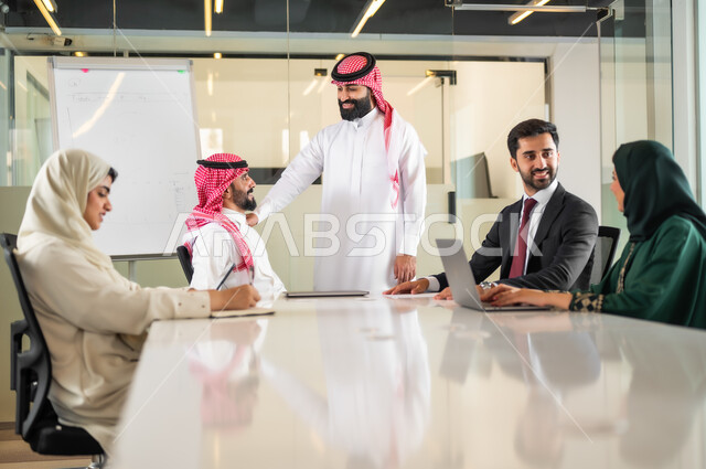 Analyzing and studying new projects, using the blackboard to explain the processes and procedures followed in the company, teamwork and team spirit, discussing work plans, ensuring a clear and comprehensive understanding of the business, using the laptop to take notes, a Saudi Gulf Arab team in a meeting inside the office