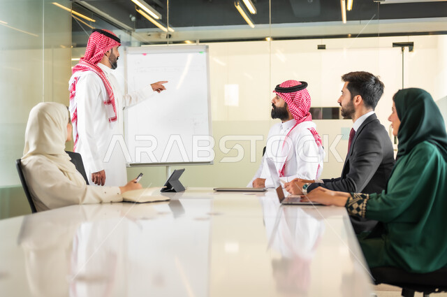 Study and analysis of new projects, using the blackboard to explain the processes and procedures followed in the company, teamwork and team spirit, discussing work plans, ensuring a clear and comprehensive understanding of the business, using the laptop to take notes, a Saudi Gulf Arab team in a meeting inside the office