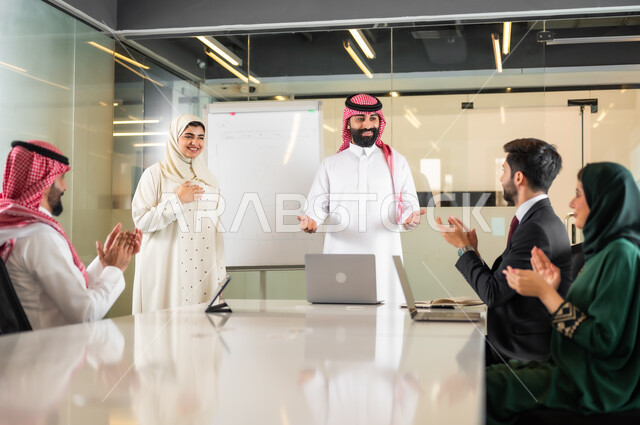 استخدام الأجهزة التقنية الحديثة في المكاتب، التفاهم والتعاون بين الزملاء لتحقيق أهداف الشركة, اجتماع عمل بين موظفين عرب خليجيين سعوديين في غرفة الاجتماعات، حوارات و مناقشات لتحقيق الاستراتيجيات والغايات، بيئة العمل المريحة في الشركات السعودية