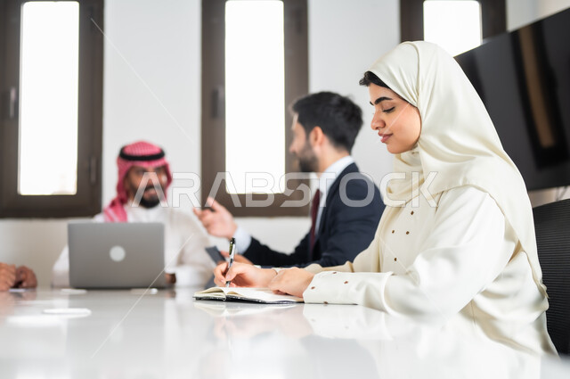 بيئة العمل المريحة في الشركات السعودية, ايماءات السعادة والسرور لبدء الشراكة، اجتماع عمل مع موظفين عرب خليجيين سعوديين في غرفة الاجتماعات، نقاشات خاصة بالعمل,التفاهم والتعاون بين الزملاء لتحقيق أهداف الشركة, استخدام الأجهزة التقنية الحديثة في المكاتب
