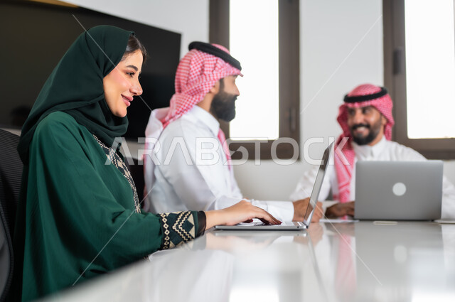 ايماءات السعادة والسرور لبدء الشراكة، اجتماع عمل مع موظفين عرب خليجيين سعوديين في غرفة الاجتماعات، بيئة العمل المريحة في الشركات السعودية,  نقاشات خاصة بالعمل,التفاهم والتعاون بين الزملاء لتحقيق أهداف الشركة, استخدام الأجهزة التقنية الحديثة في المكاتب