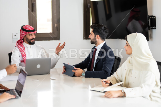 التفاهم والتعاون بين الزملاء لتحقيق أهداف الشركة, نقاشات خاصة بالعمل, استخدام الأجهزة التقنية الحديثة في المكاتب،  ايماءات السعادة والسرور لبدء الشراكة، اجتماع عمل مع موظفين عرب خليجيين سعوديين في غرفة الاجتماعات، بيئة العمل المريحة في الشركات السعودية,