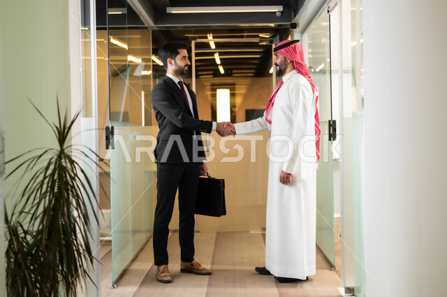 مهن ووظائف سعودية, العمل في الشركات الخليجية الراقية, التحية والسلام والاتفاق على صفقات عمل ناجحة, رجلا أعمال عربيان خليجيان سعوديان يقومان بالمصافحة بتعابير السرور, الاتفاق على المشاريع والخطط التجارية