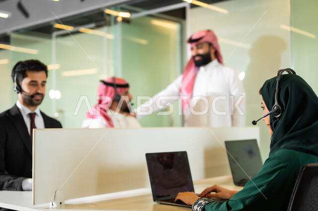 متابعة وتطوير العمل في الشركات السعودية, مظفون عرب سعوديون خليجيون يعملون في خدمة العملاء داخل مقر العمل, ارتداء سماعة الاتصال للتواصل مع العملاء, الإجابة عن الاستعلامات والاستفسارات