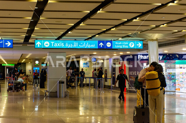 الديكورات الداخليه والفن الهندسي المتميز لمطار دبي الدولي، مسافرون يقفون في صالات استقبال المسافرين، شاشات الكترونية ارشادية، السياحة والسفر في الإمارات العربية المتحدة، اهم مركز جوي في الشرق الاوسط