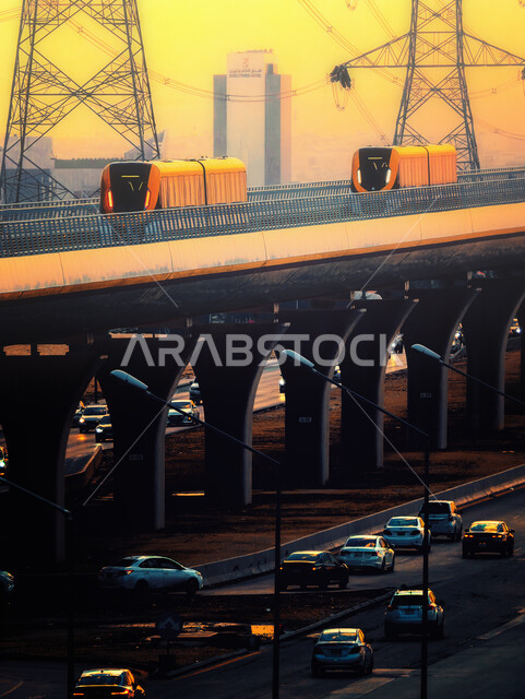 الجسر المعلق المدعوم بالكوابل في وقت غروب الشمس، قطار خط مترو مدينة الرياض في المملكة العربية السعودية، وسائل النقل والمواصلات السريعة، التصميم الهندسي المعماري للطرق والشوارع بالعاصمة، حركة المرور وسير السيارات في الشوراع الرئيسية