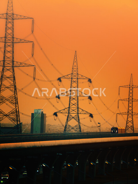 قطار خط مترو مدينة الرياض في المملكة العربية السعودية، وسائل النقل والمواصلات السريعة، التصميم الهندسي المعماري للطرق والشوارع بالعاصمة، حركة المرور وسير السيارات في الشوراع الرئيسية، الجسر المعلق المدعوم بالكوابل في وقت غروب الشمس