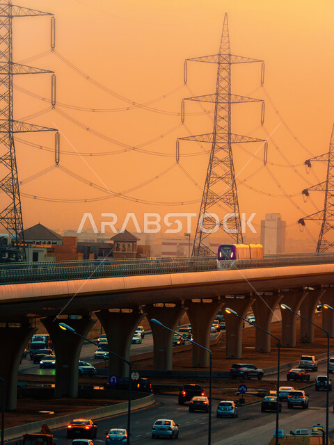 حركة المرور وسير السيارات في الشوراع الرئيسية، الجسر المعلق المدعوم بالكوابل في وقت غروب الشمس، قطار خط مترو مدينة الرياض في المملكة العربية السعودية، وسائل النقل والمواصلات السريعة، التصميم الهندسي المعماري للطرق والشوارع بالعاصمة