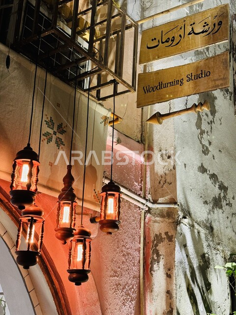 الأضواء وفوانيس الزينة المعلقة، صورة مقربة للافتة ارشادية لورشة ارومات الأثرية في جدة البلد، أماكن ومعالم سياحية تاريخية قديمة في المملكة العربية السعودية