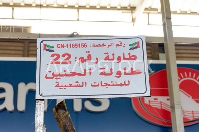 لافتة بعبارة طاولة الحنين للمنتجات الشعبية، محاصيل ومنتجات زراعية محلية وطنية إماراتية، موسم قطاف المحصول الزراعي في إمارة ابو ظبي، الاهتمام بالزراعة المحلية والاكتفاء الذاتي في الإمارات العربية المتحدة، أسواق شعبية لبيع الخضار والفواكه الطازجة في مدينة العين