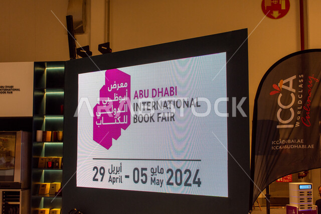 The Abu Dhabi International Book Fair logo on a large electronic screen in one of the sections, exhibitions and events in the United Arab Emirates, famous cultural landmarks and places in the Emirate of Abu Dhabi, the world of books and publishing.