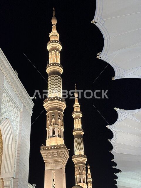 العبادة والتقرب إلى الله، صورة مقربة لمنارة المسجد النبوي الشريف في المدينة المنورة المضيئة ليلا،  الفن الهندسي المعماري على الطراز الإسلامي، أماكن ومعالم دينية مقدسة بالمملكة العربية السعودية