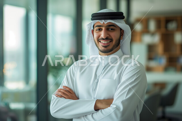 الاهتمام بالأناقة والمظهر الخارجي، مهن و وظائف مكتبية، صورة مقربة لرجل أعمال عربي خليجي سعودي مبتسم يرتدي الشماغ والثوب التقليدي يقف باستقامة ينظر الى الكاميرا بإيماءات السرور والثقة بالنفس، شركات المملكة العربية السعودية