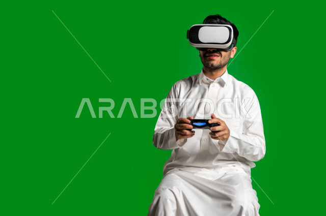 كروما ، رجل سعودي خليجي سعيد ،يضع جهازVR Box، ايماءات وجه و يدين تدل على السعادة و الاستمتاع ، استخدام تقنية ثلاثية الابعاد ، خلفية خضراء