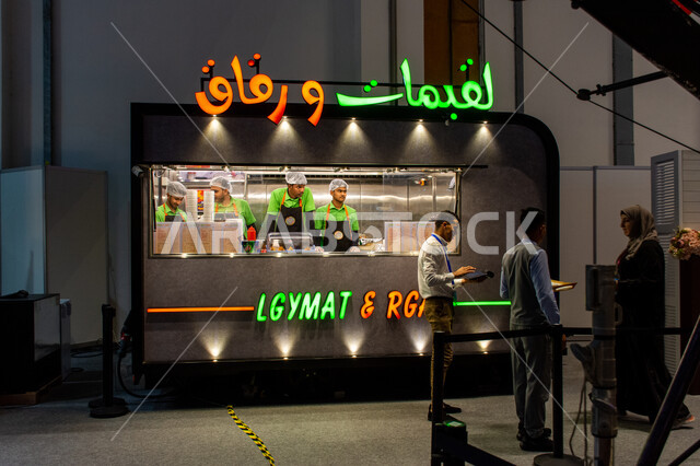 محل كشك لبيع اللقيمات والرقاق الإماراتية في معرض أبوظبي الدولي للكتاب لعام2024، آكلات شعبية تقليدية من التراث الإماراتي، فعاليات ومعارض في الإمارات العربية المتحدة،عالم الكتب والنشر، معالم وأماكن سياحية شهيرة في إمارة أبو ظبي