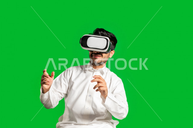 كروما ، رجل سعودي خليجي سعيد ،يضع جهازVR Box، ايماءات وجه و يدين تدل على السعادة و الاستمتاع ، استخدام تقنية ثلاثية الابعاد ، خلفية خضراء