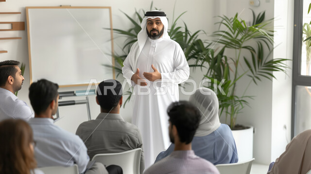 Discussing and teaching employees the foundations and goals of successful work, a Saudi Gulf Arab professor wearing the traditional dress and ghutra, giving an educational lecture, the concept of united teamwork, exchanging experiences and dialogue on applying modern and advanced methods, qualification and training workshops.