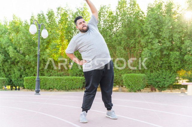  شاب سعودي خليجي يمارس الرياضة الصباحية في الهواء الطلق ،ممارسة تمارين الكارديو الصباحية  ، القيام  بتمارين لياقة متعددة ، نشاط بدني  للمحافظة على اللياقة و الصحة الجيدة ، ممارسة التمارين الرياضية 