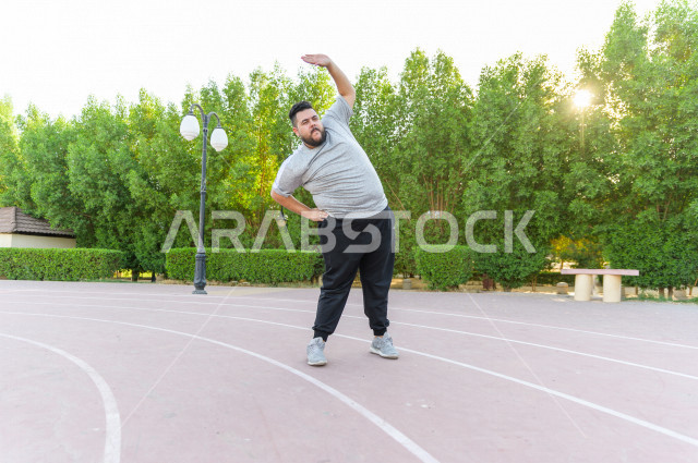  شاب سعودي خليجي يمارس الرياضة الصباحية في الهواء الطلق ،ممارسة تمارين الكارديو الصباحية  ، القيام  بتمارين لياقة متعددة ، نشاط بدني  للمحافظة على اللياقة و الصحة الجيدة ، ممارسة التمارين الرياضية 