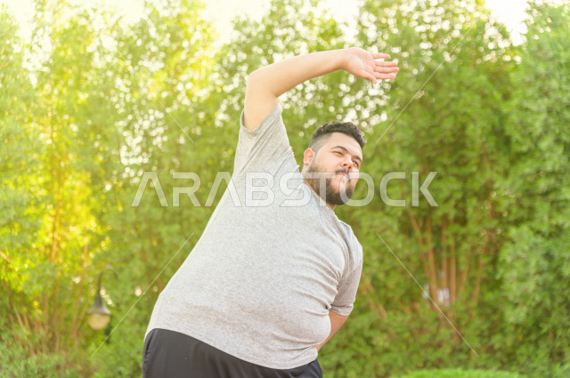  شاب سعودي خليجي يمارس الرياضة الصباحية في الهواء الطلق ،ممارسة تمارين الكارديو الصباحية  ، القيام  بتمارين لياقة متعددة ، نشاط بدني  للمحافظة على اللياقة و الصحة الجيدة ، ممارسة التمارين الرياضية 