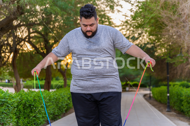  شاب سعودي خليجي يمارس الرياضة الصباحية في الهواء الطلق ،ممارسة تمارين الكارديو الصباحية  ، القيام  بتمارين لياقة متعددة ، نشاط بدني  للمحافظة على اللياقة و الصحة الجيدة ، ممارسة التمارين الرياضية 