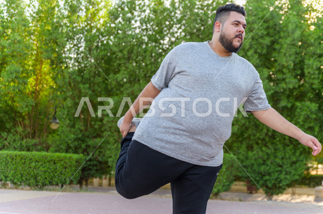 شاب سعودي خليجي يمارس الرياضة الصباحية في الهواء الطلق ،ممارسة تمارين الكارديو الصباحية  ، القيام  بتمارين لياقة متعددة ، نشاط بدني  للمحافظة على اللياقة و الصحة الجيدة ، ممارسة التمارين الرياضية 