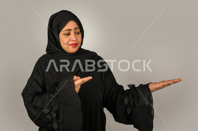 Portrait of an elderly Saudi woman in a happy Gulf, different face and hands gestures, different facial and hand expressions, white background