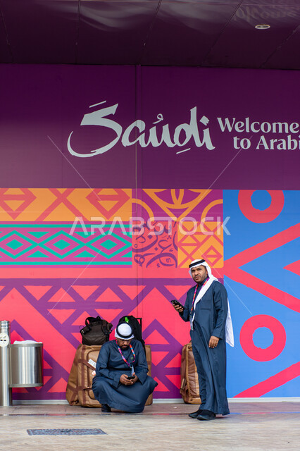 جذب واستقطاب السياح من انحاء العالم،، مشاركة سعودية في سوق السفر العربي بدبي 2024، السياحة في المملكة العربية السعودية، قطاع السياحة والخدمات، صورة  لرجلان عربيان خليجيان سعوديان يرتديان الثوب التقليدي و الشماغ، مؤتمرات في الإمارات العربية المتحدة.