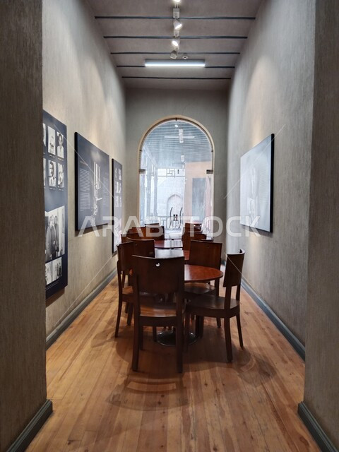 A council of friends of Naguib Mahfouz to meet and exchange conversations, a table and chairs, and a group of pictures hanging on the walls of friends, a room equipped with luxurious furniture, famous archaeological and cultural heritage places and landmarks.